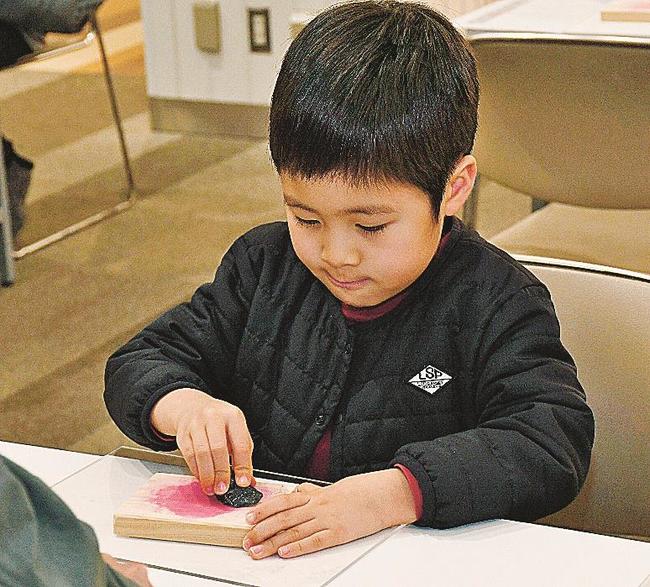 一生懸命に石を磨く子ども＝松江市東朝日町、イオン松江ショッピングセンター