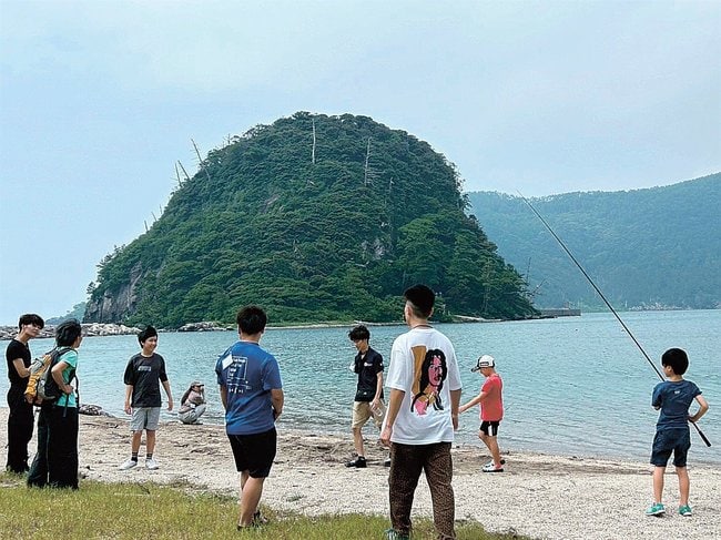 魚釣りをして親睦を深める子どもたちとボランティア＝島根県隠岐の島町北方、福浦海水浴場