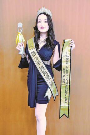 準グランプリのトロフィーを持ちポーズを決める幸田芙沙さん＝松江市殿町、島根県庁