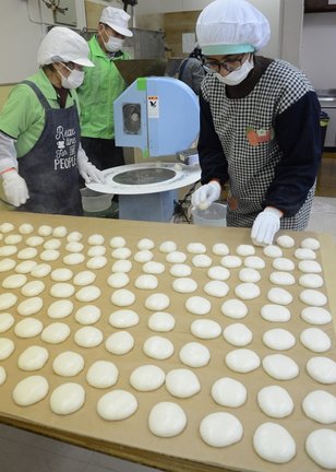 つき上がった餅を並べる住民たち＝安来市広瀬町西比田、旧ＪＡ比田マーケット