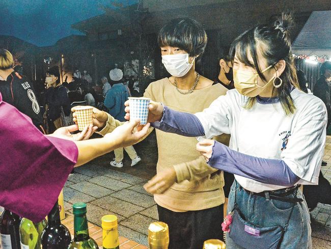 出雲ナイトマルシェで飲み物を受け取る来場者＝出雲市大社町杵築南