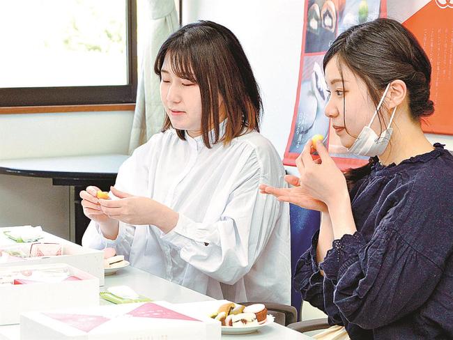 「ご縁をむすび」の商品を試食する女子学生＝松江市浜乃木７丁目、県立大学松江キャンパス