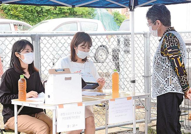 ワクチン接種希望者にカレンダーを指し示しながら接種日を説明するスタッフ＝松江市黒田町、泉胃腸科医院
