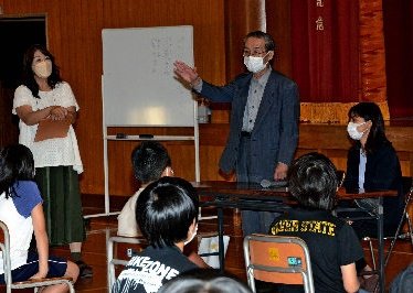 太平洋戦争末期の空襲の記憶を伝える安江英彦さん(中央)と宍道香穂記者(右)=米子市両三柳、米子市立加茂小学校