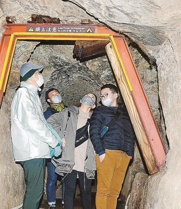 龍源寺間歩を案内する山根幸文さん（左）＝大田市大森町