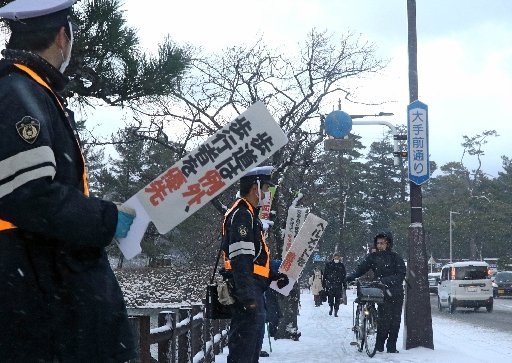 自転車利用者に注意を呼びかける警察官=松江市殿町
