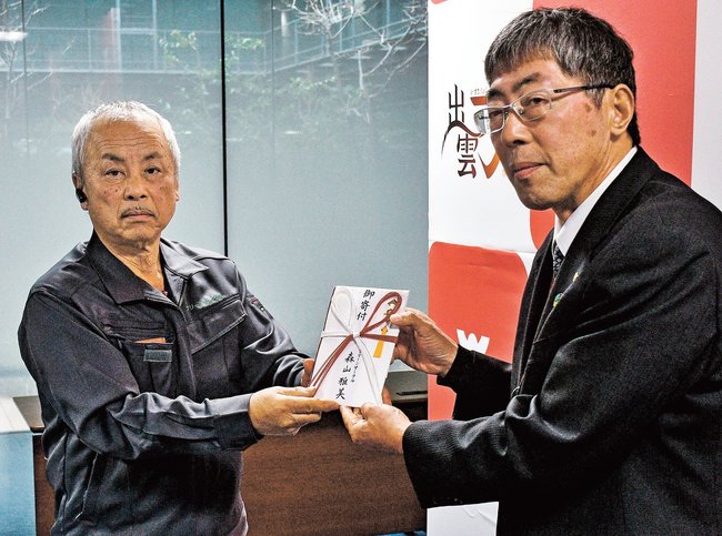 寄付金を手渡す森山雅美代表（左）＝出雲市今市町、市役所