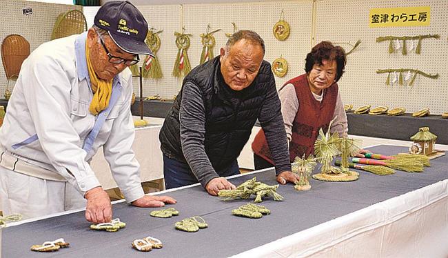 わら細工の作品を並べる室津わら工房の会員＝出雲市多伎町口田儀、多伎文化伝習館