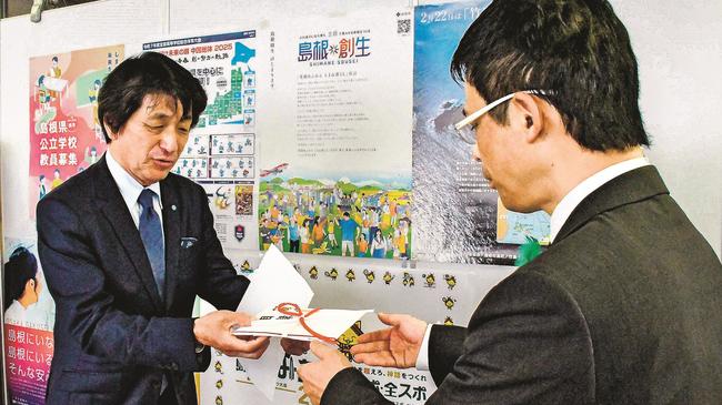 野津建二教育長に目録を手渡すエフエム山陰の小村健実社長（左）＝松江市殿町、島根県教育委員会