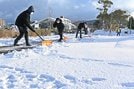 雪かきをする職員＝２２日午前８時２３分、松江市学園南１丁目、市総合体育館
