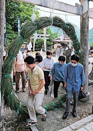 無病息災を願い、茅の輪をくぐる参列者＝島根県川本町川本、弓ケ峯八幡宮