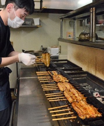 タレをつけたウナギを次々と焼く従業員＝松江市学園２丁目、うなぎ圓松江学園通り店