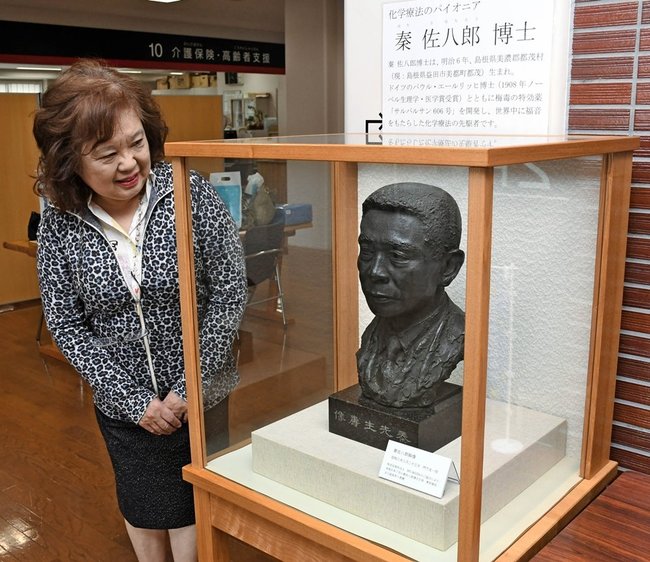 益田市役所に展示された秦佐八郎博士の胸像を見る秦はるひさん＝益田市常盤町