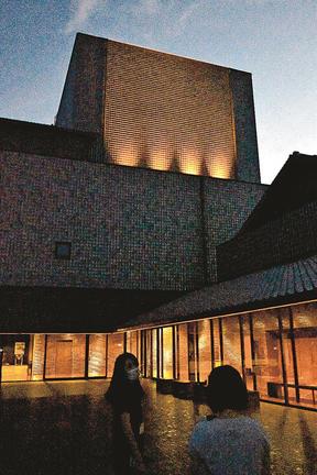オレンジ色にライトアップされたグラントワの壁面＝益田市有明町