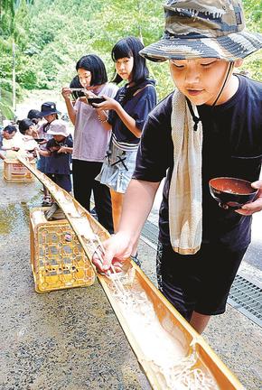名水に乗って流れるそうめんを味わう来場者＝安来市広瀬町奥田原、嫁来い観音・婿来い地蔵