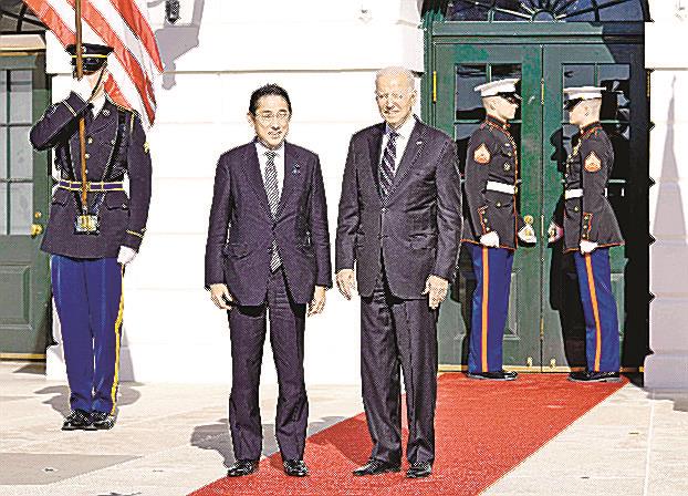 首脳会談を前にバイデン米大統領（右）の出迎えを受ける岸田首相＝１３日、ワシントンのホワイトハウス（共同）