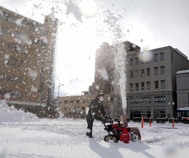 再び積もった雪を除雪機で除雪する人＝松江市殿町