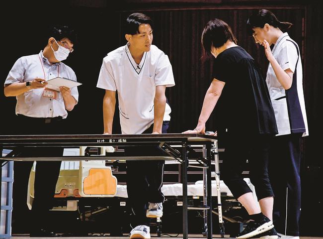 機能回復の足踏み体操をする邇摩高校の生徒（左から２人目と右端）＝松江市西津田６丁目、プラバホール