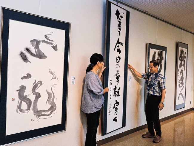 作品を並べる大賀美秀峯支部長（右）ら島根県独立書人団出雲支部のメンバー＝出雲市塩冶有原町２丁目、市民会館