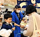 ミニ北海道フェアの会場で試食を味わう親子＝松江市朝日町、一畑百貨店