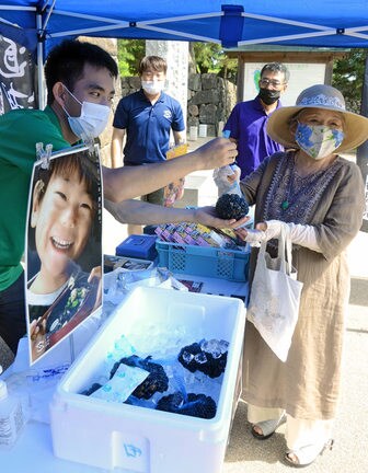 松江城の朝市で宍道湖産シジミを買い求める来訪者（右）＝松江市殿町