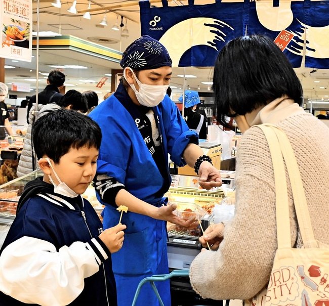 ミニ北海道フェアの会場で試食を味わう親子＝松江市朝日町、一畑百貨店