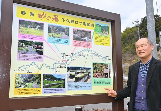 映画「砂の器」ロケ地の案内看板を紹介する植田覚さん＝雲南市大東町下久野