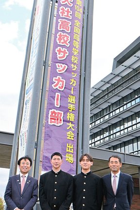 懸垂幕の前で活躍を誓う栗原貫志主将(左から2人目)ら=出雲市今市町、市役所