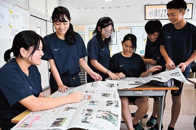 新聞紙面を広げ、見出しやレイアウトについて学ぶ生徒たち＝益田市匹見町匹見、匹見中学校