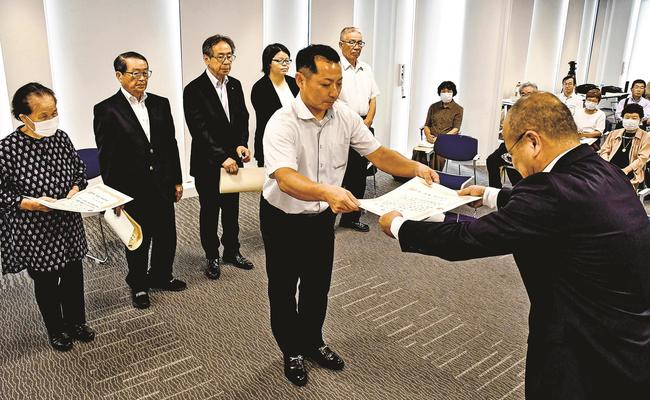 石飛厚志市長（右）から表彰状を受け取る市民活動団体の関係者＝雲南市木次町里方、市役所