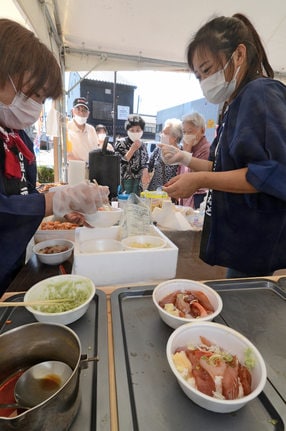 海鮮を盛ったどんぶりの用意をする出展者＝境港市相生町
