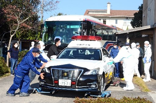 施錠して動けなくなったパトカーを脇に寄せる境港署員ら＝１２日午前１０時２５分ごろ、境港市誠道町の旧誠道小学校