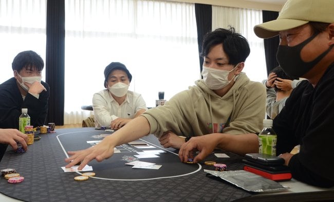 大会参加者とポーカーを楽しむ高橋英晴代表（左から３人目）＝松江市浜乃木５丁目、乃木公民館