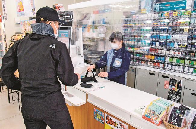 強盗役の川本署員に対応する店員（右）＝島根県美郷町粕渕、ローソン・ポプラ美郷町粕渕店