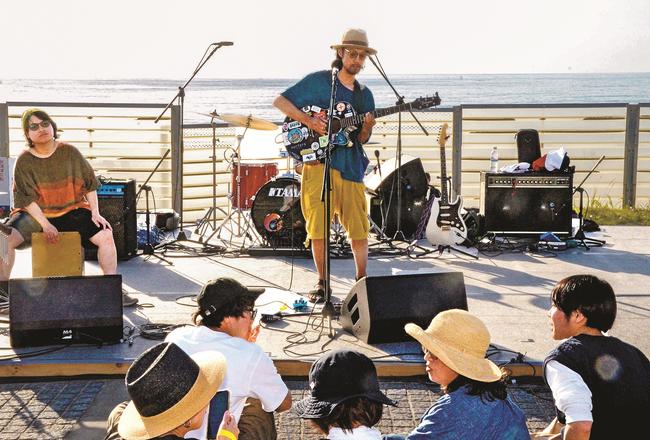 海を背に演奏するミュージシャン＝浜田市下府町、国府海水浴場