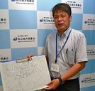天気図を手に説明する海老さん。「予報官の仕事は、自然災害から人の命と財産を守るため適切な防災気象情報を出すことに尽きる」と語る＝松江市西津田７丁目、松江地方気象台