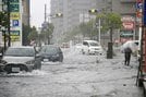 冠水した道路を走る車＝８日午前９時30分、松江市黒田町