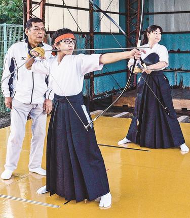 山本修三会長（左）の指導を受けながら的を狙う福谷颯介さん（手前）＝大田市水上町、市立第三中学校