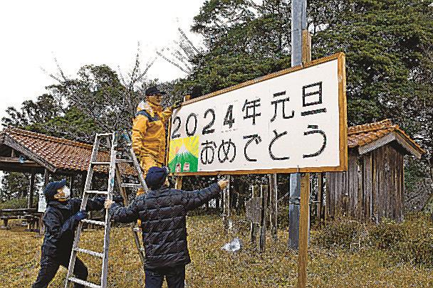 大道山の山頂に電飾看板を設置する住民＝益田市中垣内町
