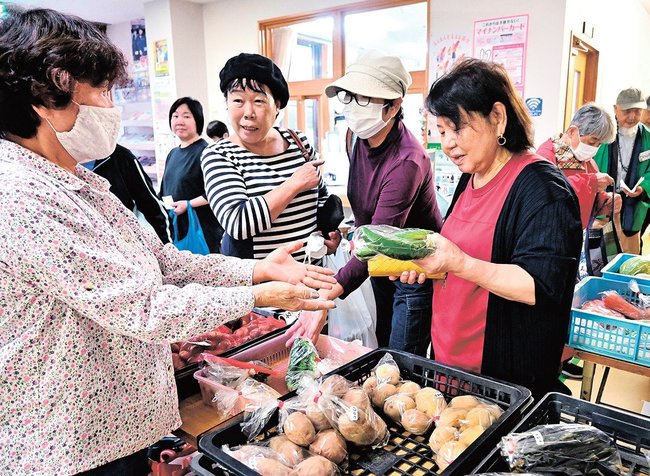 朝市で野菜を買い求める来場者＝浜田市内村町、美川まちづくりセンター