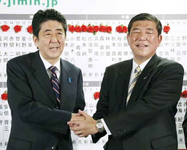 衆院選で大幅に議席を増やし、笑顔で握手する自民党の安倍晋三総裁（左）と石破茂幹事長（ともに当時）＝２０１２年１２月１６日夜、東京・永田町の党本部