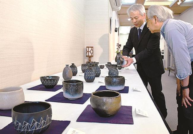 来場者に作品を紹介する内田和秀さん（奥）＝松江市殿町、紫泉堂ギャラリー