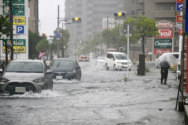 冠水した道路を走る車＝８日午前９時30分、松江市黒田町
