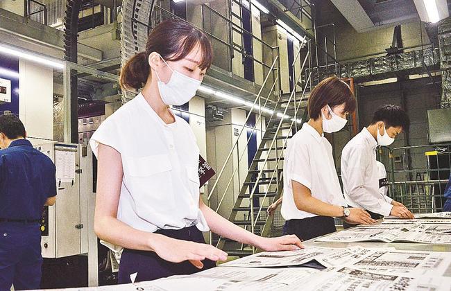 刷り上がった選挙公報をチェックする県選挙管理委員会の職員＝出雲市斐川町上庄原、山陰中央新報製作センター