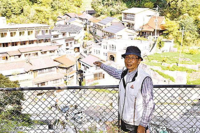 有福温泉街の眺望を紹介する湯町自治会の盆子原温会長＝江津市有福温泉町