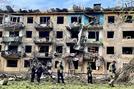 ４月３０日、ウクライナ東部ドネツク州で、ミサイル攻撃を受けた建物の周辺を調べるウクライナ兵ら（ロイター＝共同）