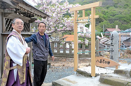 整備した境内を幡垣裕行宮司に案内する若松隆さん＝松江市鹿島町手結、津上神社