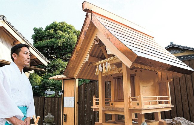 白蛇神の祠について説明する井上浩修宮司=松江市西持田町、持田神社