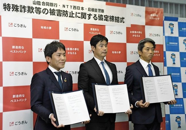 協定書を掲げる（左から）小田晃弘支店長、高橋毅営業統括部長、中井淳一本部長＝松江市殿町、島根県警本部