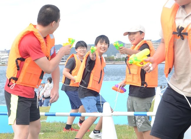 水鉄砲で相手の的をねらうミズサバの参加者＝松江市袖師町、岸公園
